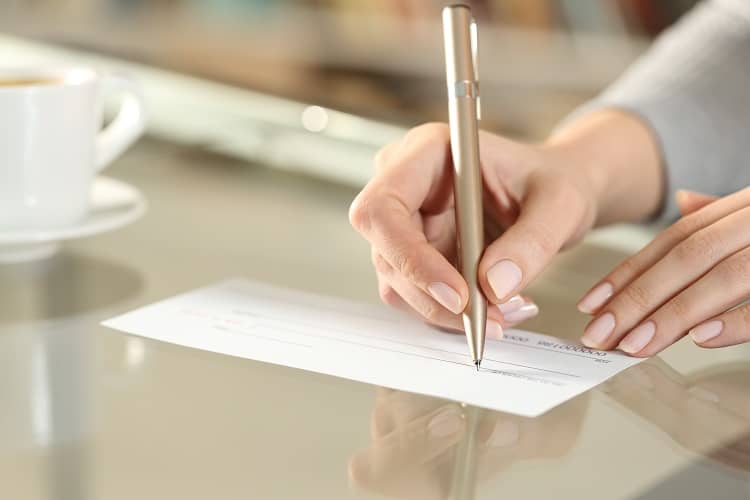 Woman writing check for rent deposit